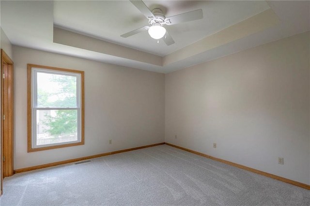 833 SW Harvest Dr, Grain Valley, MO 64029 - unfurnished room with baseboards, a tray ceiling, light carpet, and a ceiling fan