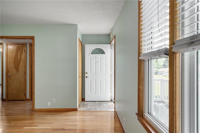 11124 W 69th Ter, Shawnee, KS 66203 - entryway with baseboards, light wood-style floors, and a textured ceiling