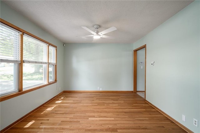 11124 W 69th Ter, Shawnee, KS 66203 - spare room with light wood-type flooring, a textured ceiling, ceiling fan, and baseboards