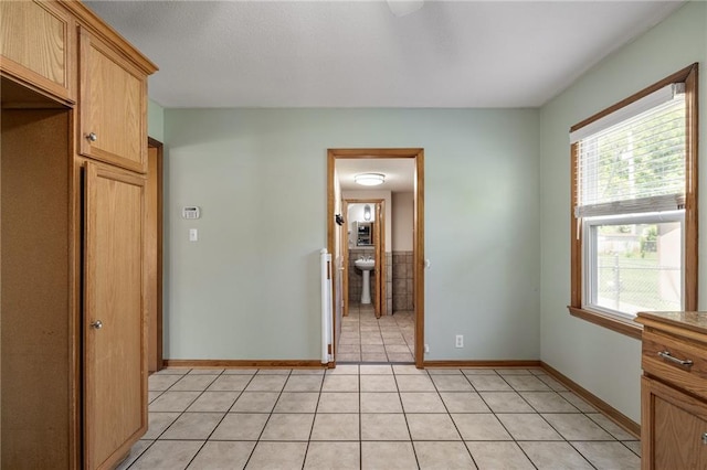 11124 W 69th Ter, Shawnee, KS 66203 - unfurnished room with plenty of natural light, baseboards, light tile patterned flooring, and a sink