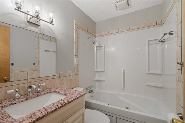 11124 W 69th Ter, Shawnee, KS 66203 - bathroom with a combined bath / shower with jetted tub, vanity, toilet, a textured ceiling, and tile walls