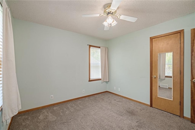 11124 W 69th Ter, Shawnee, KS 66203 - spare room featuring carpet floors, a textured ceiling, a ceiling fan, and baseboards