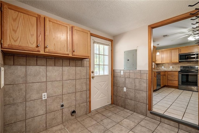 11124 W 69th Ter, Shawnee, KS 66203 - kitchen with stainless steel appliances, electric panel, tile walls, light tile patterned floors, and a textured ceiling