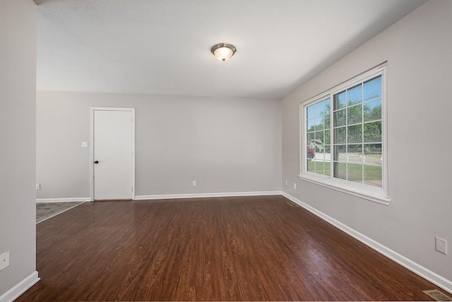 1180 Greenwood Pkwy, Tonganoxie, KS 66086 - spare room featuring dark wood finished floors and baseboards