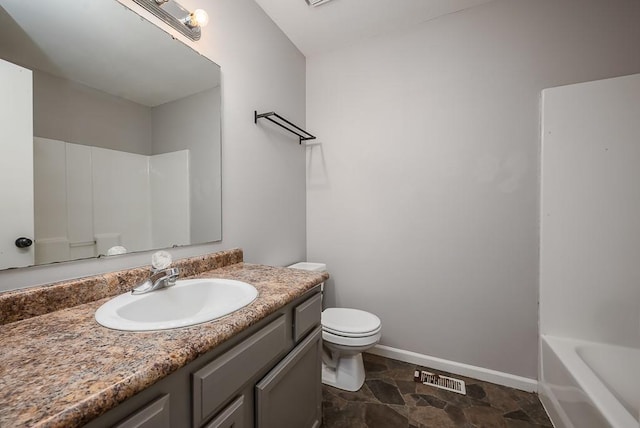 1180 Greenwood Pkwy, Tonganoxie, KS 66086 - bathroom with vanity, toilet, baseboards, and stone finish floors