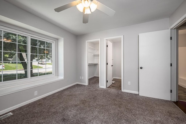 1180 Greenwood Pkwy, Tonganoxie, KS 66086 - unfurnished bedroom featuring dark colored carpet, baseboards, a spacious closet, and a ceiling fan