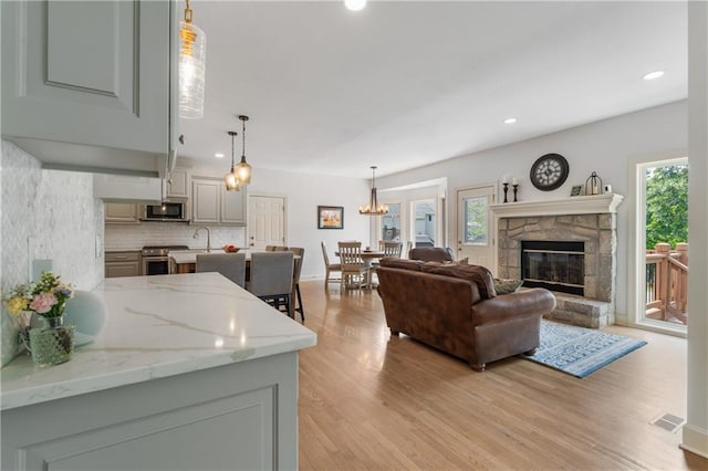 13897 W 140th St, Olathe, KS 66062 - living area featuring light wood-style flooring, a fireplace, recessed lighting, and baseboards