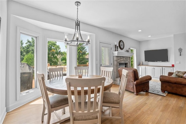 13897 W 140th St, Olathe, KS 66062 - dining area with light wood-style flooring, a chandelier, a fireplace, recessed lighting, and baseboards
