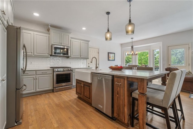 13897 W 140th St, Olathe, KS 66062 - kitchen featuring stainless steel appliances, gray cabinets, a sink, a breakfast bar area, and recessed lighting