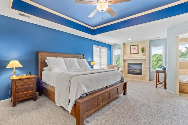 13897 W 140th St, Olathe, KS 66062 - carpeted bedroom with a tile fireplace, baseboards, a tray ceiling, and ceiling fan