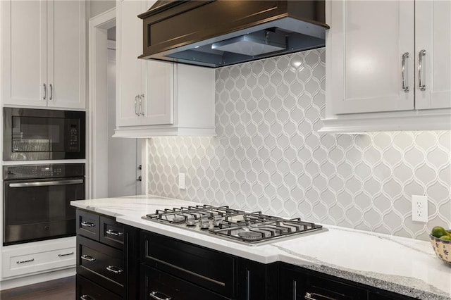 5947 N Cosby St, Kansas City, MO 64151 - kitchen with wall oven, custom range hood, black microwave, stainless steel gas cooktop, and light stone counters