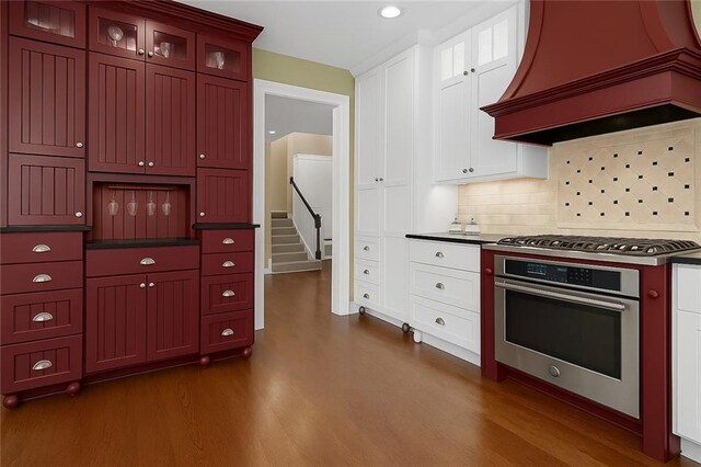 12712 W 126th St, Overland Park, KS 66213 - kitchen with stainless steel appliances, dark wood finished floors, custom exhaust hood, dark countertops, and recessed lighting