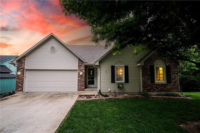 1604 S 105th Ter, Edwardsville, KS 66111 - view of front facade featuring brick siding, concrete driveway, an attached garage, and a yard