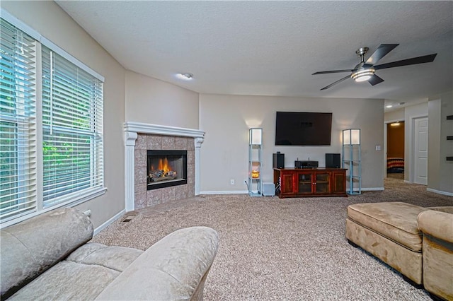 1604 S 105th Ter, Edwardsville, KS 66111 - living room with carpet flooring, ceiling fan, a textured ceiling, a tiled fireplace, and baseboards