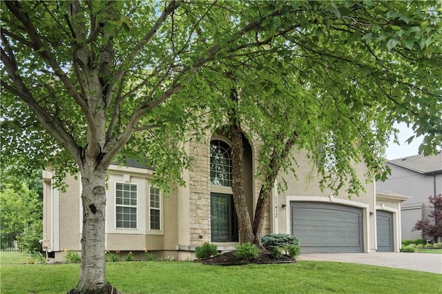 11412 S Lakecrest Dr, Olathe, KS 66061 - obstructed view of property with a front lawn, stucco siding, concrete driveway, and an attached garage