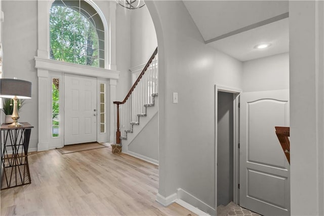 11412 S Lakecrest Dr, Olathe, KS 66061 - foyer with wood finished floors, arched walkways, baseboards, a towering ceiling, and stairs