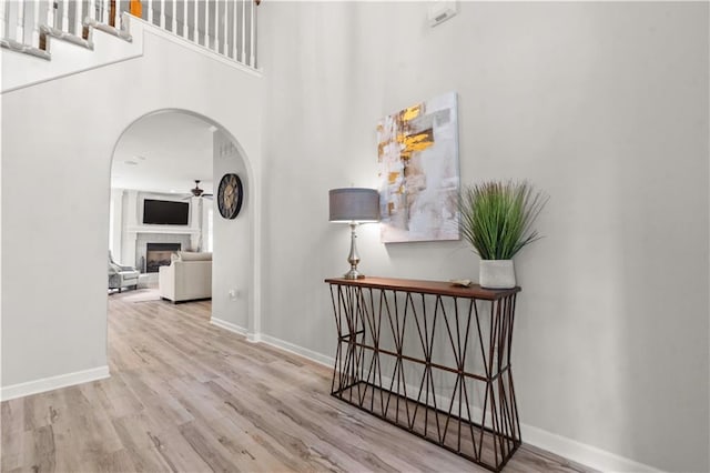 11412 S Lakecrest Dr, Olathe, KS 66061 - hallway featuring arched walkways, wood finished floors, baseboards, and a towering ceiling