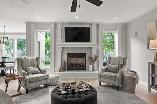 11412 S Lakecrest Dr, Olathe, KS 66061 - living room with ceiling fan, crown molding, wood finished floors, a fireplace with raised hearth, and recessed lighting