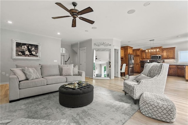 11412 S Lakecrest Dr, Olathe, KS 66061 - living room featuring a ceiling fan, light wood-type flooring, ornamental molding, recessed lighting, and arched walkways