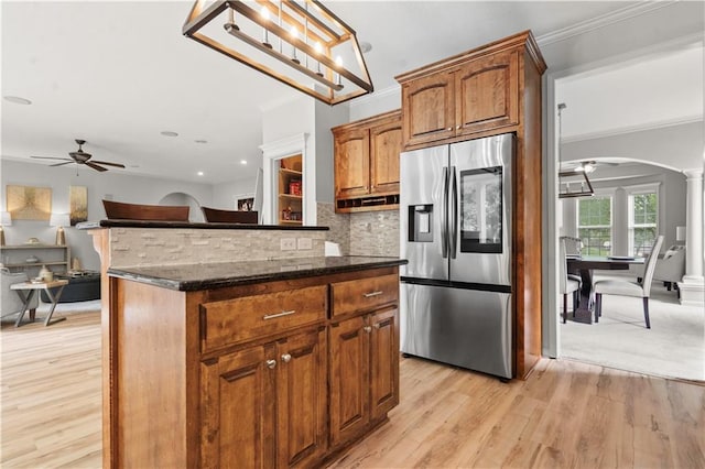 11412 S Lakecrest Dr, Olathe, KS 66061 - kitchen featuring stainless steel fridge, ceiling fan, arched walkways, light wood-type flooring, and dark stone counters