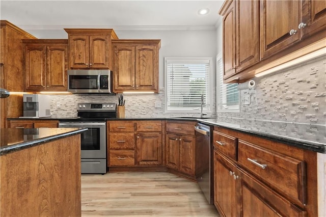 11412 S Lakecrest Dr, Olathe, KS 66061 - kitchen with stainless steel appliances, a sink, ornamental molding, light wood-style floors, and backsplash