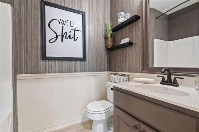 11412 S Lakecrest Dr, Olathe, KS 66061 - full bath with wallpapered walls, vanity, toilet, wainscoting, and bathtub / shower combination