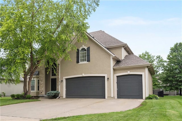 11412 S Lakecrest Dr, Olathe, KS 66061 - traditional-style house with driveway, a front lawn, stucco siding, a garage, and roof with shingles