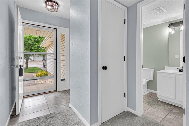 1413 SE Norwood Dr, Lees Summit, MO 64081 - entrance foyer with a textured ceiling, a textured wall, baseboards, and light tile patterned floors