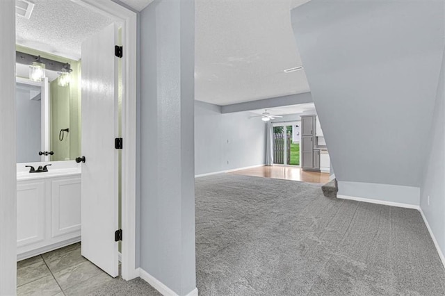 1413 SE Norwood Dr, Lees Summit, MO 64081 - unfurnished room with a textured ceiling, baseboards, ceiling fan, light colored carpet, and a sink