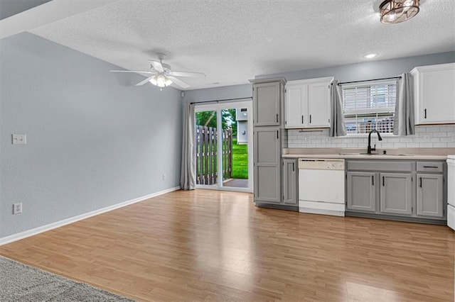 1413 SE Norwood Dr, Lees Summit, MO 64081 - kitchen with dishwasher, a sink, a textured ceiling, backsplash, and gray cabinetry