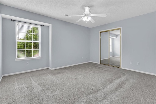 1413 SE Norwood Dr, Lees Summit, MO 64081 - unfurnished bedroom featuring multiple windows, carpet flooring, a textured ceiling, a closet, and baseboards