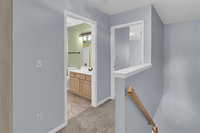1413 SE Norwood Dr, Lees Summit, MO 64081 - corridor featuring an upstairs landing, light colored carpet, baseboards, a textured ceiling, and a sink