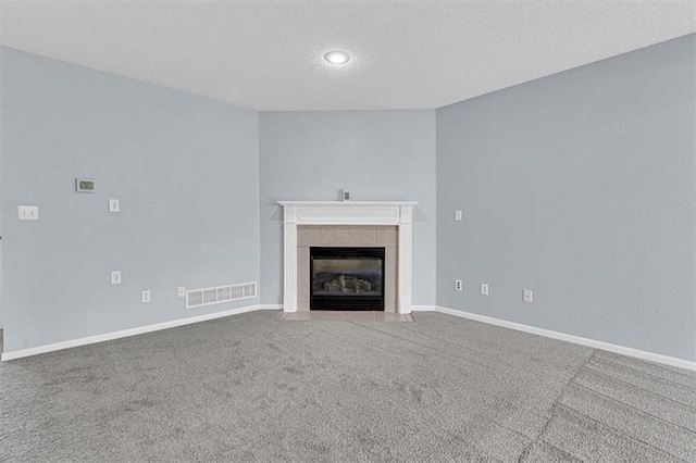 1413 SE Norwood Dr, Lees Summit, MO 64081 - unfurnished living room with a textured ceiling, a tile fireplace, carpet, and baseboards