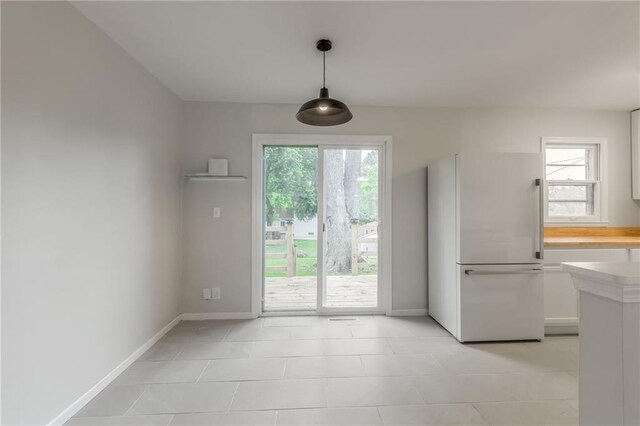 704 W 38th St N, Independence, MO 64052 - unfurnished dining area with light tile patterned floors and baseboards