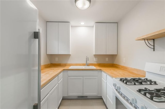 704 W 38th St N, Independence, MO 64052 - kitchen featuring white gas range, a sink, wood counters, freestanding refrigerator, and white cabinetry