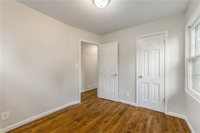 704 W 38th St N, Independence, MO 64052 - unfurnished bedroom with baseboards and wood finished floors