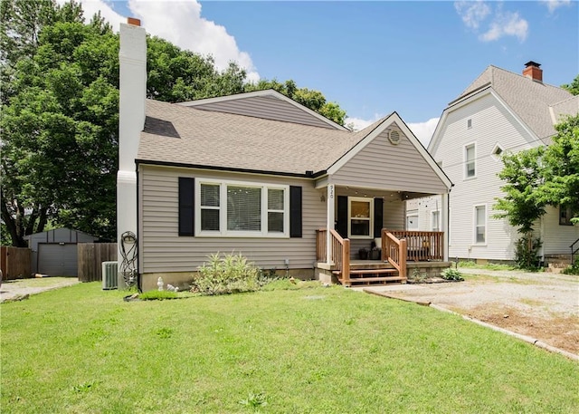 920 S Washington St, Independence, MO 64050 - bungalow-style home featuring an outbuilding, a front lawn, a chimney, and roof with shingles