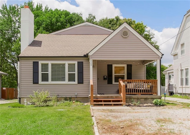920 S Washington St, Independence, MO 64050 - bungalow-style home featuring a front lawn, a chimney, covered porch, and a shingled roof