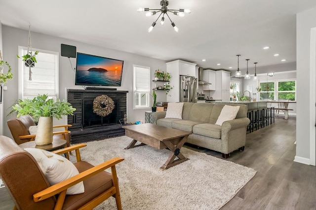 920 S Washington St, Independence, MO 64050 - living room featuring a chandelier, dark wood finished floors, recessed lighting, and a fireplace with raised hearth