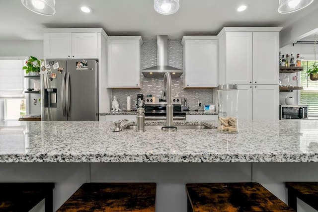 920 S Washington St, Independence, MO 64050 - kitchen with appliances with stainless steel finishes, wall chimney range hood, light stone countertops, decorative backsplash, and recessed lighting