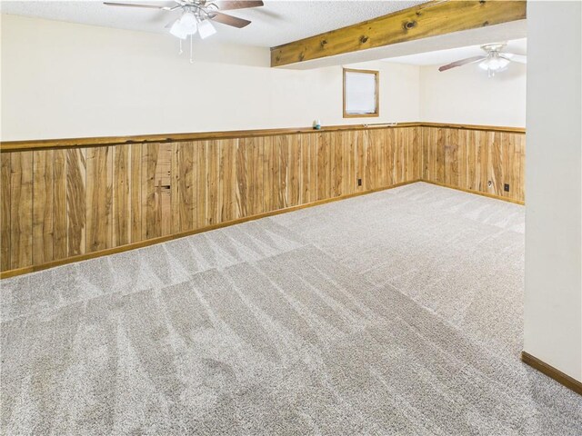 240 SE 121st Rd, Warrensburg, MO 64093 - empty room featuring a ceiling fan, carpet, wainscoting, wooden walls, and beamed ceiling