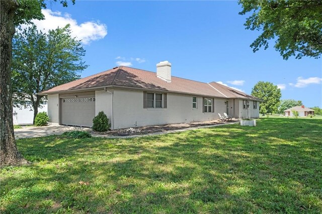 22617 155th St, Basehor, KS 66007 - rear view of property with a garage, a yard, a chimney, concrete driveway, and brick siding