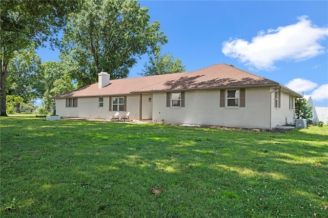 22617 155th St, Basehor, KS 66007 - rear view of house with a chimney, brick siding, and a yard