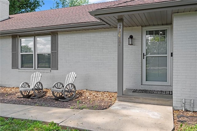 22617 155th St, Basehor, KS 66007 - view of exterior entry featuring brick siding and roof with shingles
