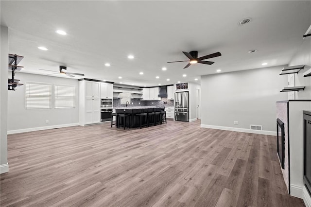 22617 155th St, Basehor, KS 66007 - living area with ceiling fan, recessed lighting, a fireplace, and light wood finished floors