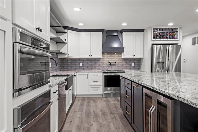 22617 155th St, Basehor, KS 66007 - kitchen featuring stainless steel appliances, wine cooler, open shelves, custom range hood, and light wood-style floors