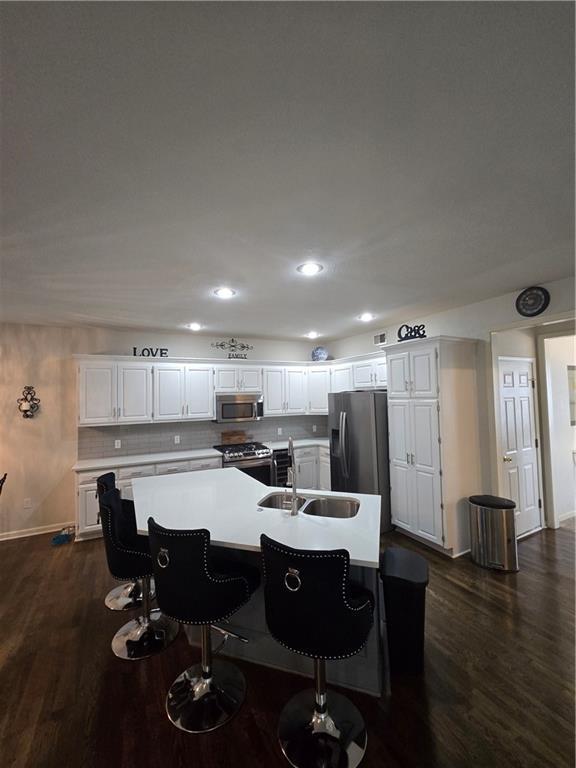 13810 W 53rd St, Shawnee, KS 66216 - kitchen with appliances with stainless steel finishes, a sink, baseboards, white cabinets, and dark wood finished floors
