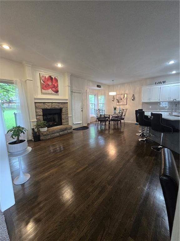 13810 W 53rd St, Shawnee, KS 66216 - living room with dark wood-style floors, plenty of natural light, a stone fireplace, recessed lighting, and baseboards