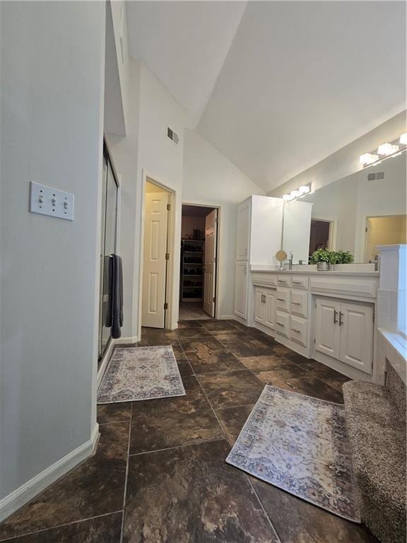 13810 W 53rd St, Shawnee, KS 66216 - bathroom featuring vanity, baseboards, high vaulted ceiling, stone finish flooring, and a stall shower