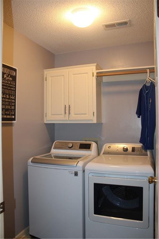 13810 W 53rd St, Shawnee, KS 66216 - laundry room featuring washing machine and dryer, a textured ceiling, and cabinet space